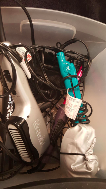 Reviewer's before picture of hair tools in one messy pile