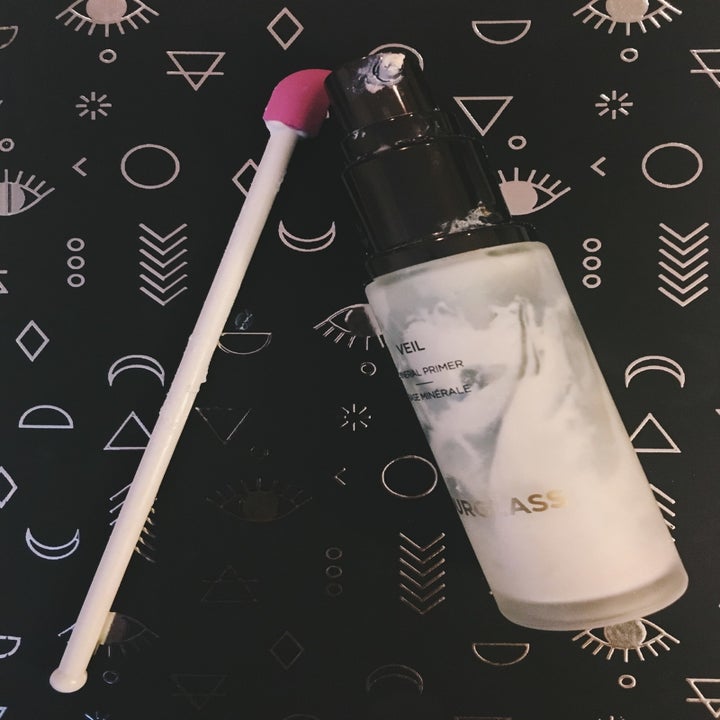 reviewer image of the spatty last drop spatula next to a nearly empty bottle of moisturizer