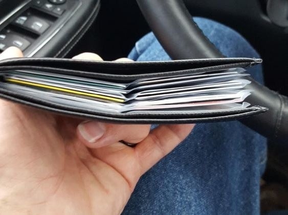 Reviewer&#x27;s picture of the thin wallet with multiple pages of plastic card slots 