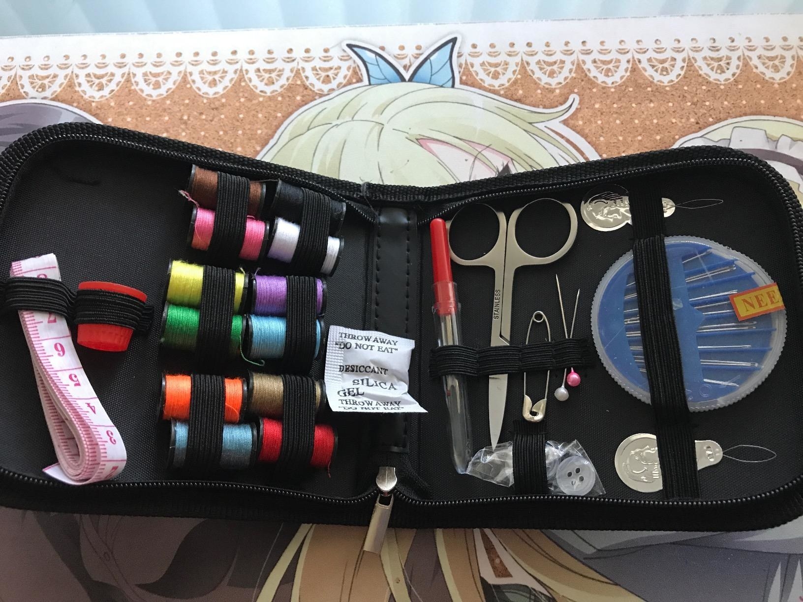 reviewer showing the inside of a travel sewing kit