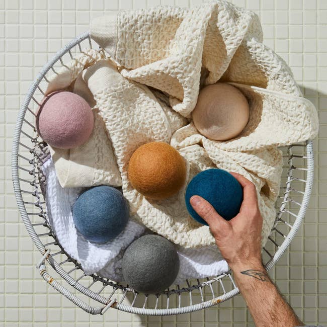 Laundry basket with several hand-sized wool balls inside 