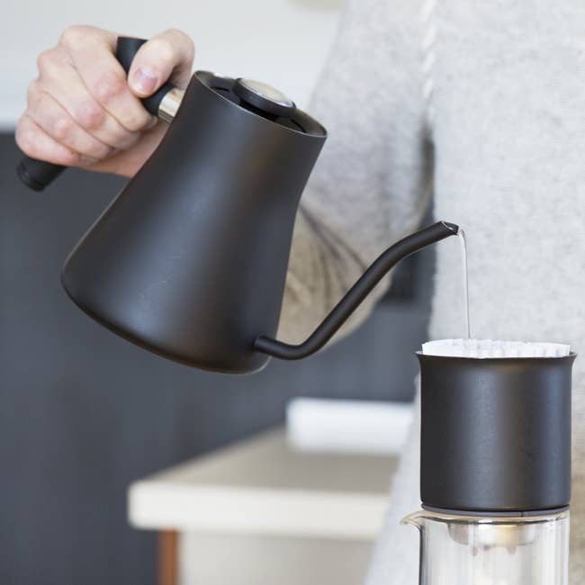 modern kettle with thin spout pouring into a filter 