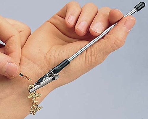 hand holds long stemmed grabby device to clasp bracelet 