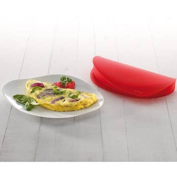 the same omelet maker next to plate with cooked veggie omelet