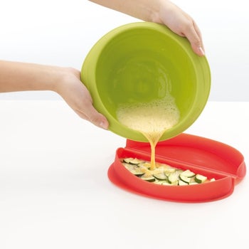 the microwave omelet maker filled with uncooked egg and veggies