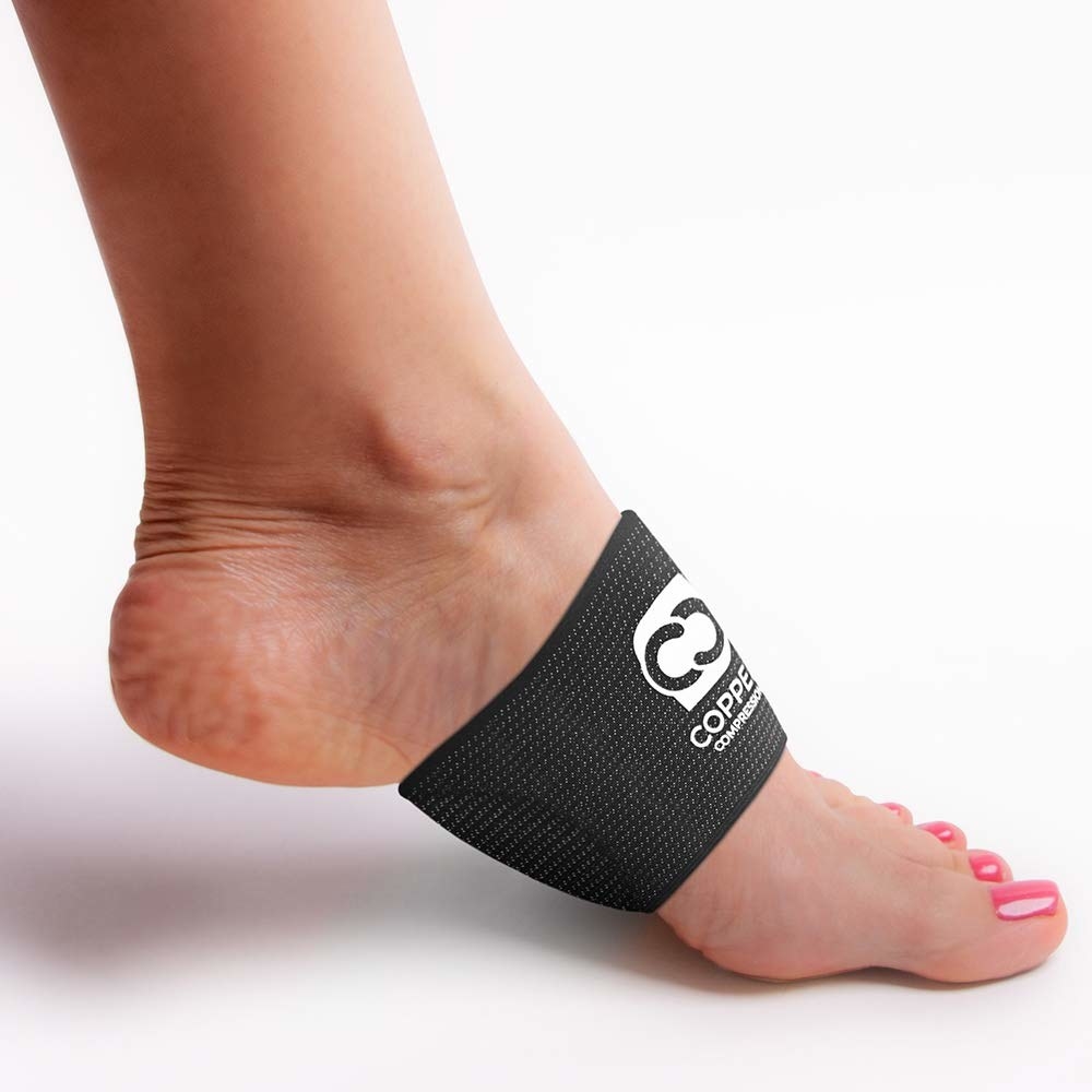 a black supportive band around the middle of a model&#x27;s foot