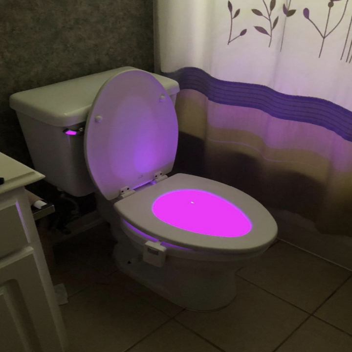 a reviewer photo of a glowing pink toilet