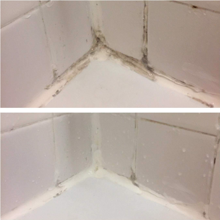 A reviewer's before: the corner of a shower, with mold in both the caulk and grout and after: the same corner, with all but a few specks of the mold gone