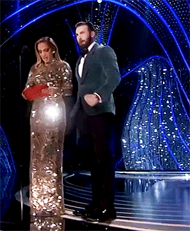 Chris Evans pumping his fist as Jennifer Lopez reads the winner next to him