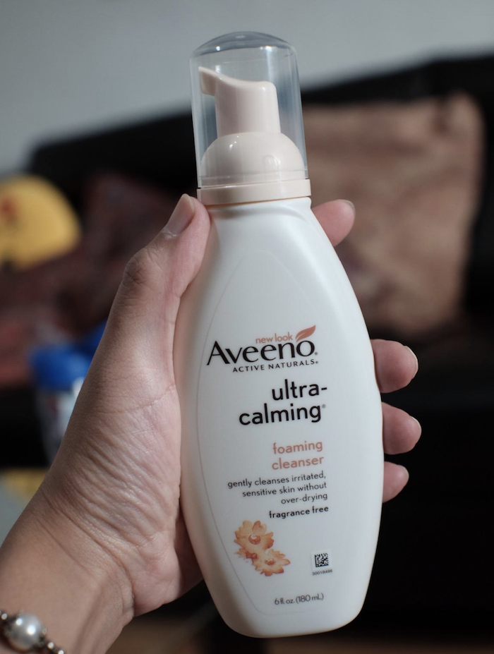 a hand holding the ultra-calming foaming cleanser 