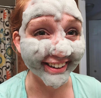 reviewer smiling with the foaming mask on their face