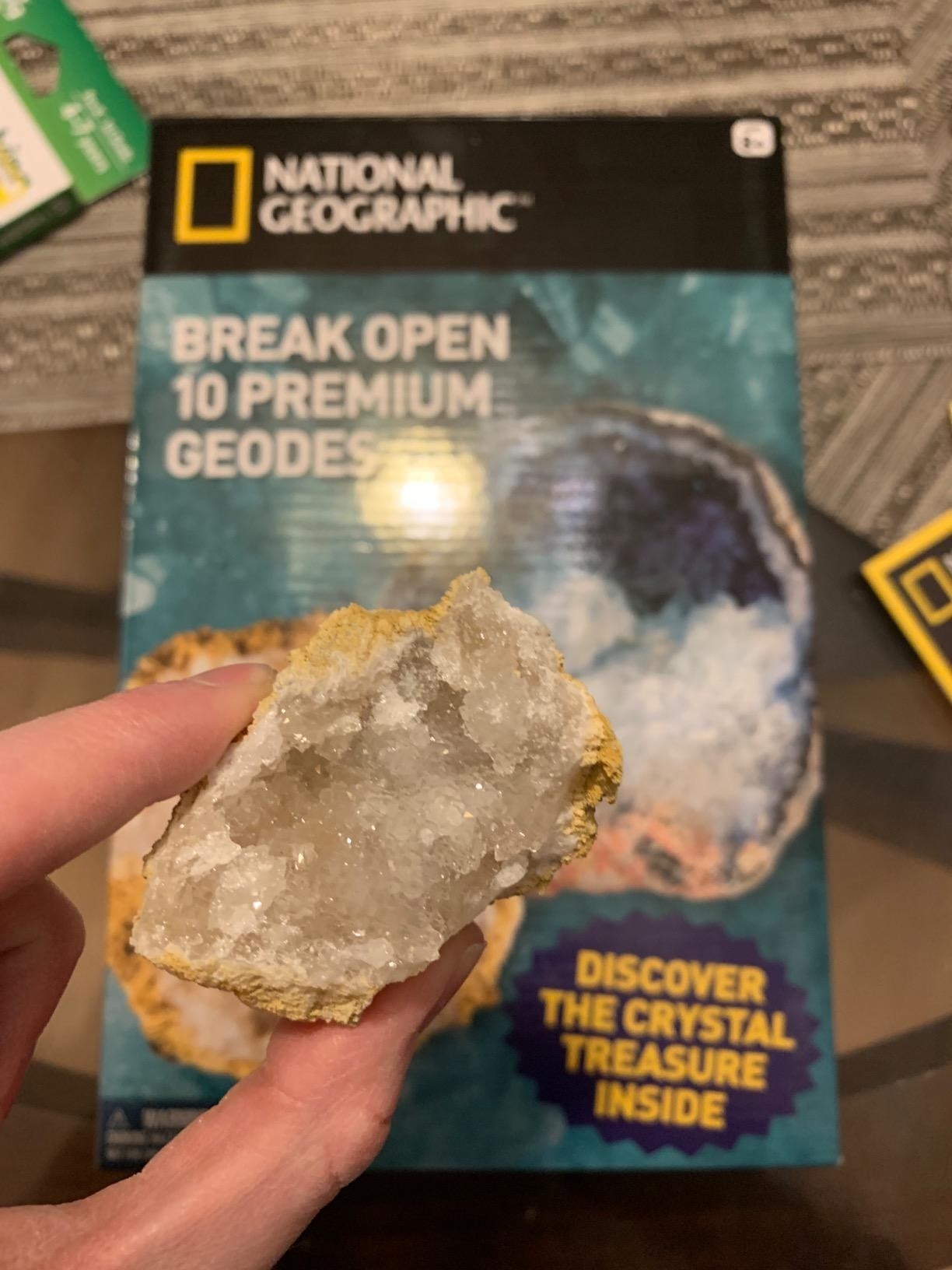 hand holds up open geode 