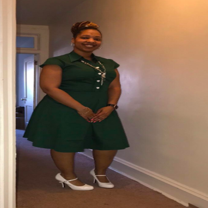 A reviewer wearing the cap sleeve, knee length dress in green