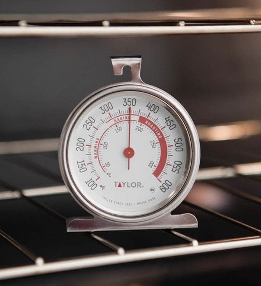 Oven thermometer on a rack displaying a temperature just below 350 degrees Fahrenheit