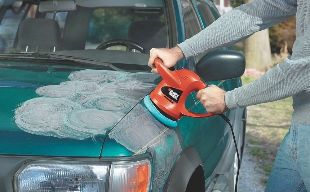 a person waxing/polishing their car