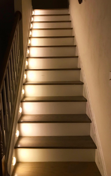 A staircase with the lights lining it making it easier to get up and down 