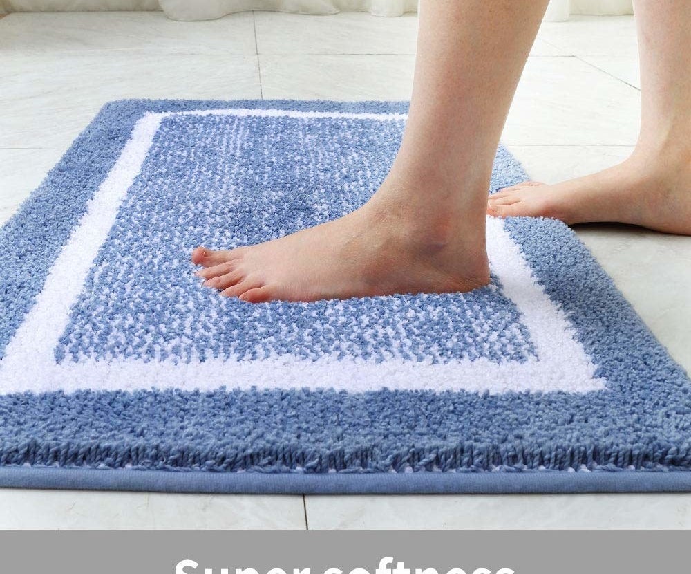 lifestyle image of someone stepping on the bath mat in blue