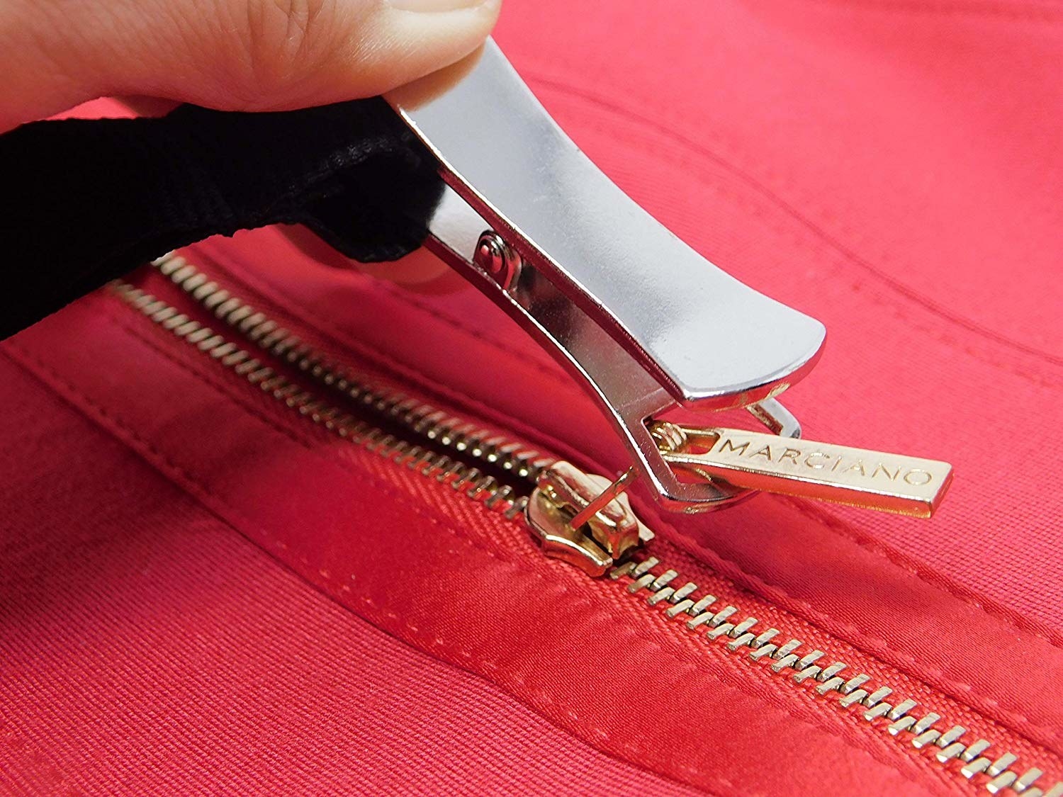 The puller looped around a zipper with a person pulling the zipper closed by pulling the attached cord