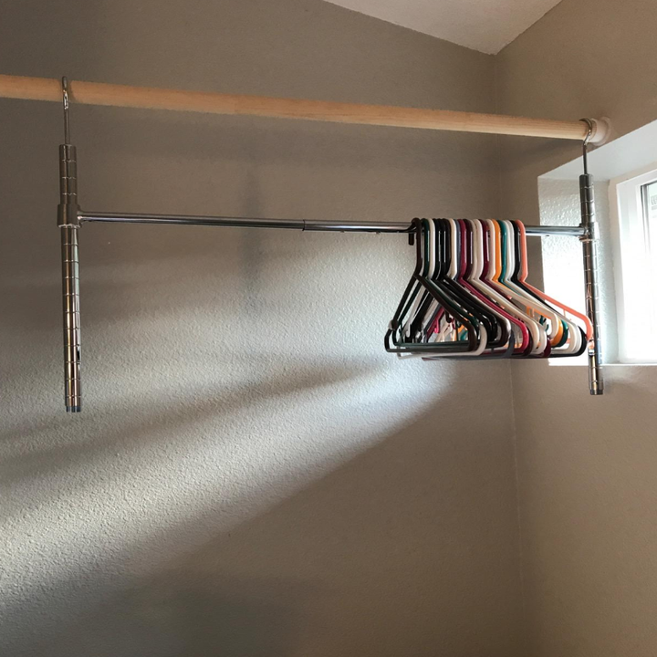 Bar with a couple of hangers below a closet pole