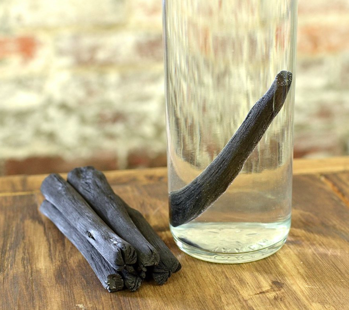 A charcoal stick inside a glass of water