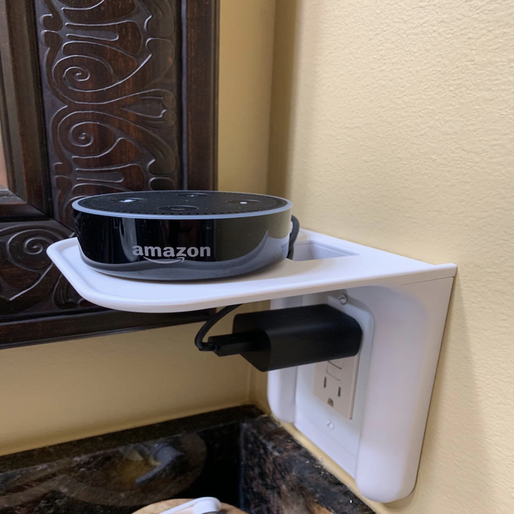 A bluetooth speaker on the power perch and plugged into the outlet below
