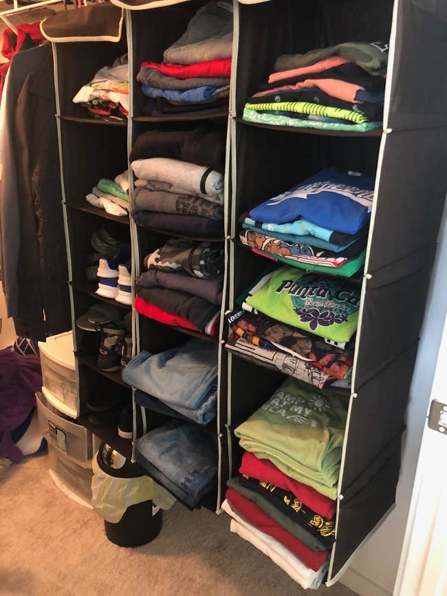 An open wardrobe organizer with neatly stacked clothes and storage bins. Perfect for a shopping article on closet solutions