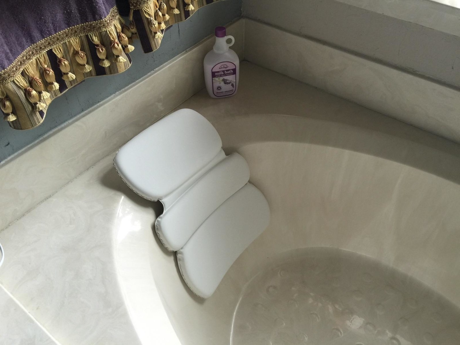 reviewer&#x27;s bath pillow in their tub 