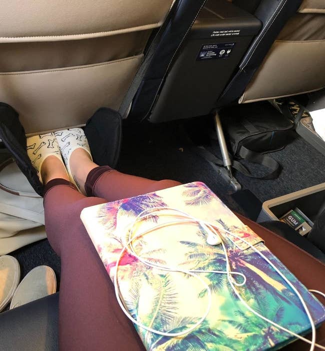 reviewer's black foot hammock on a plane with feet in them