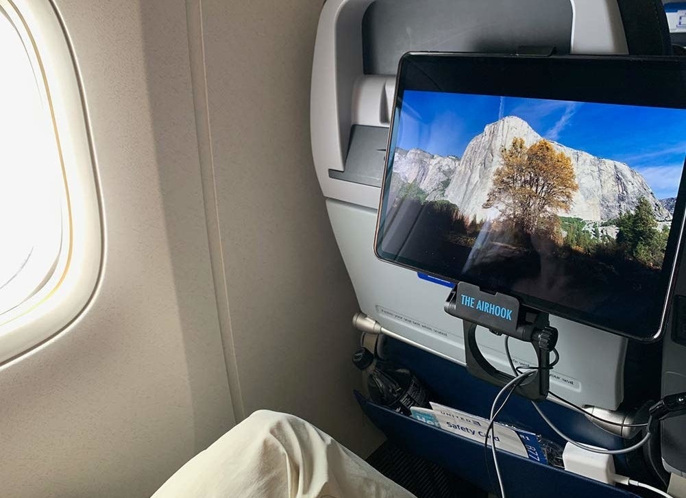 the hook attached to the back of a plane seat with an iPad attached to it