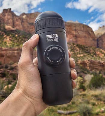 hand holding the espresso maker, showing it’s about the size of a travel cup
