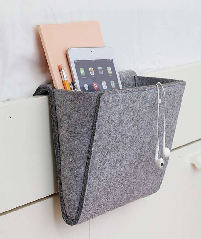 gray bedside caddy on side of white bed