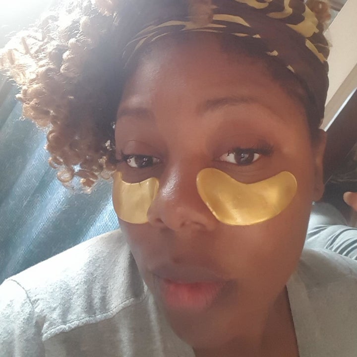 reviewer wearing the gold eye pads