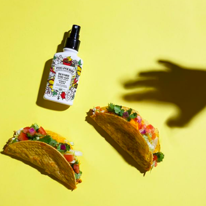 a bottle of poo pourri next to two tacos