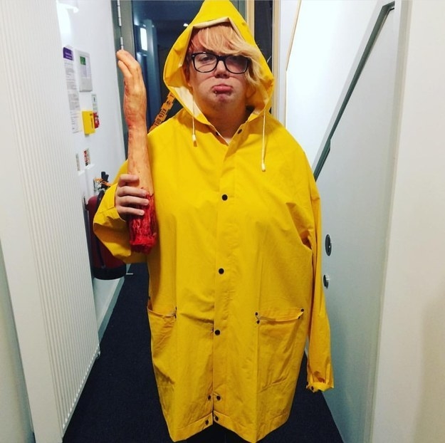 Someone in a yellow rain jacket while holding their own fake arm