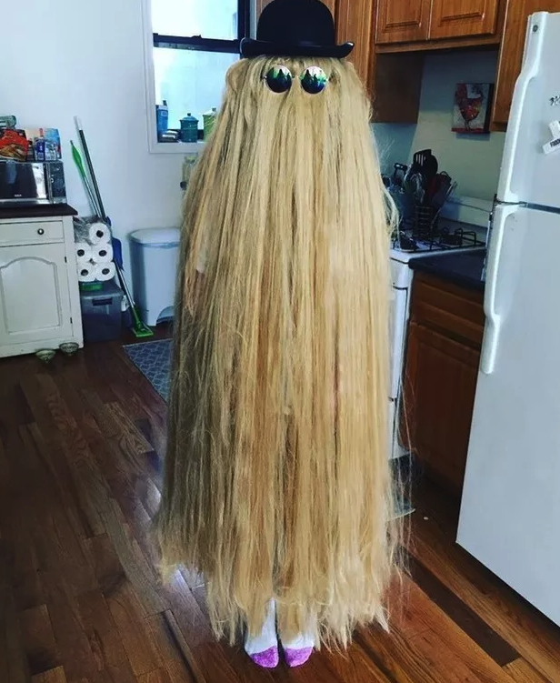 Someone dressed as Cousin Itt with hair covering their entire body