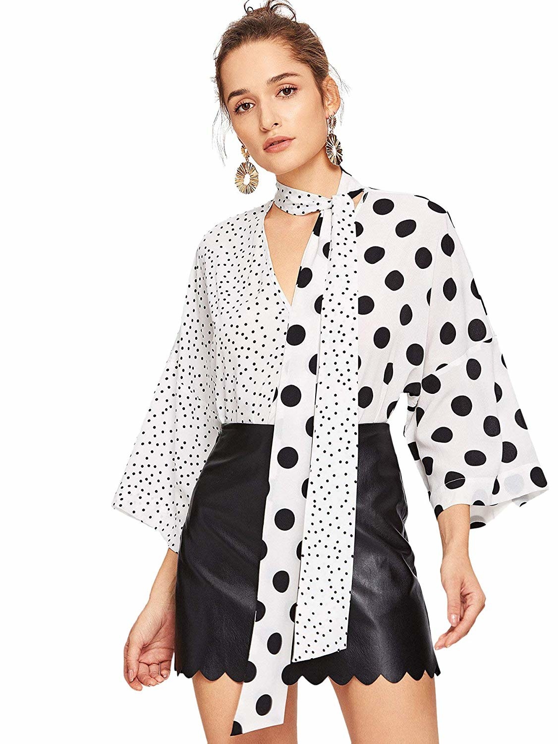 Model in the tie-neck blouse, with one side in white with tiny black polka-dots and the other half white with large black polka-dots