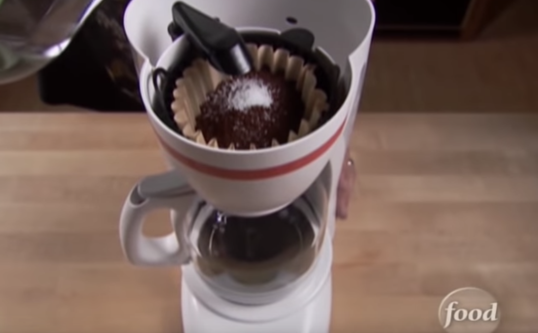 Coffee grounds and salt visible through the open top of a coffee maker