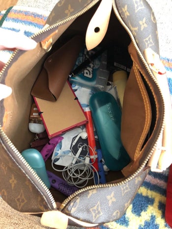 reviewer image of their purse before using the organizer with everything inside a mess
