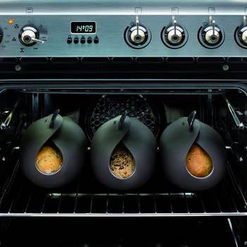 Bread makers folded closed, with three loaves cooking in oven