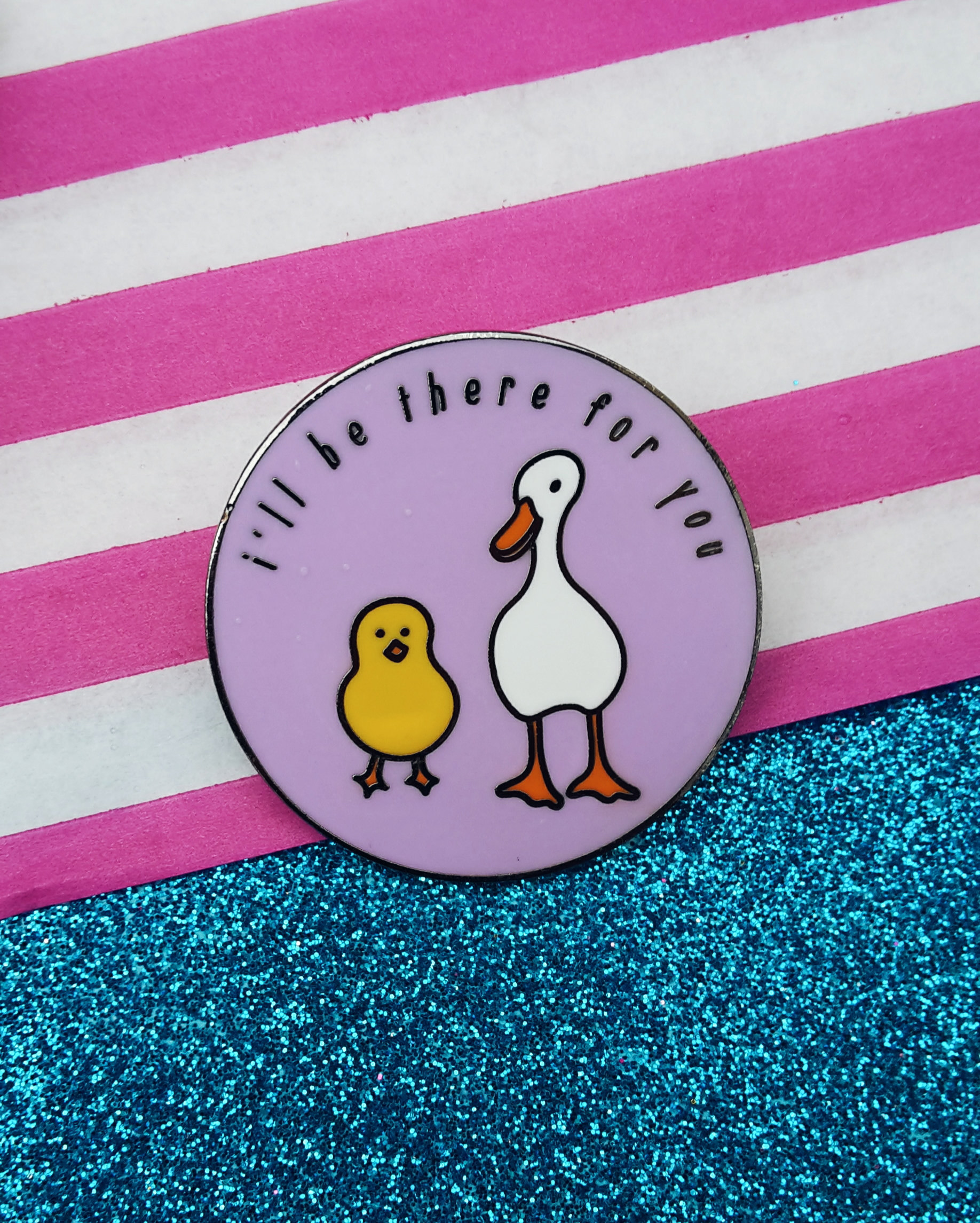 a purple circular pin with a duck and chick on it and the words i&#x27;ll be there for you