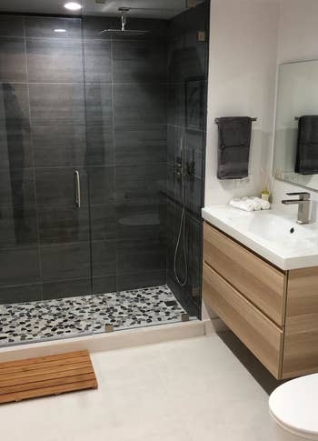reviewer photo of the bath mat in front of a walk-in shower