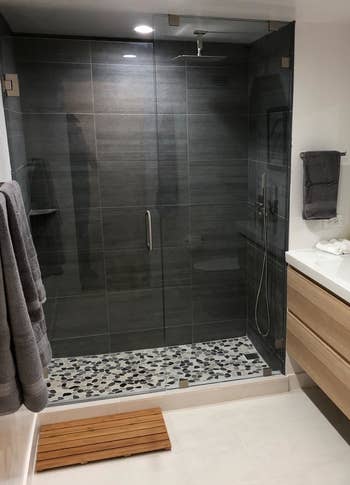 reviewer photo of the bath mat in front of a walk-in shower