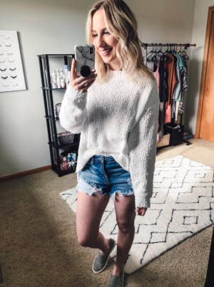 A reviewer wearing the sweater in white