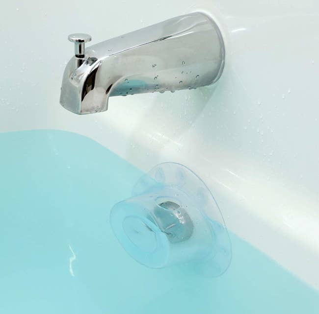 the clear cover placed over the bath's overflow drain, allowing the tub to be filled past the level of the overflow drain