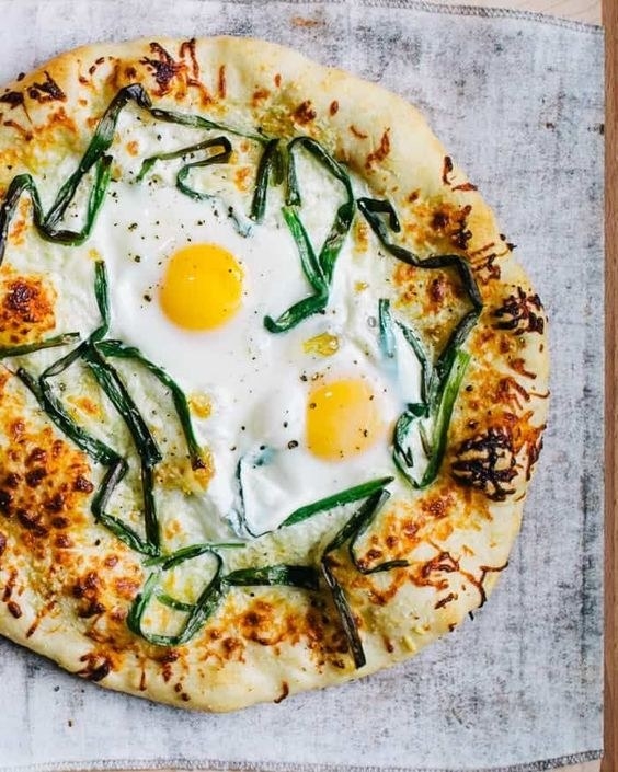 Pizza with sunny-side-up eggs on it