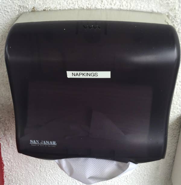 Paper towel dispenser labeled "napkings"