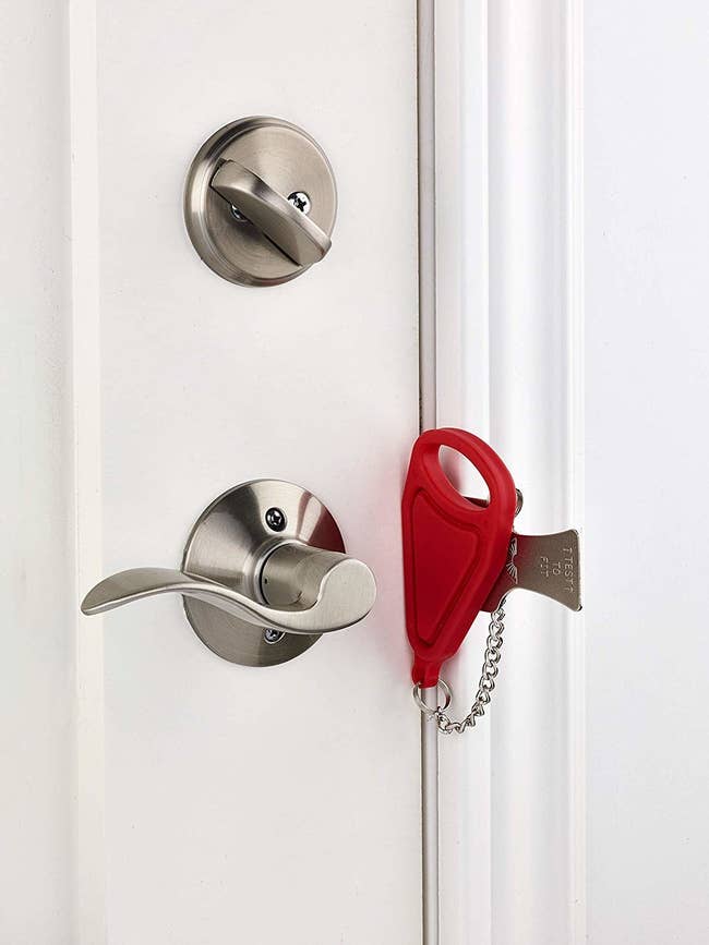 Thin red lock and metal addition slid into doorframe 