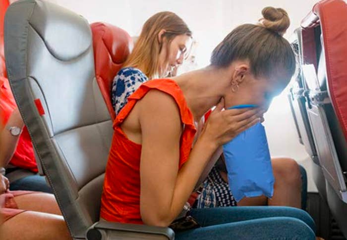 Person vomiting into bag while on a plane 