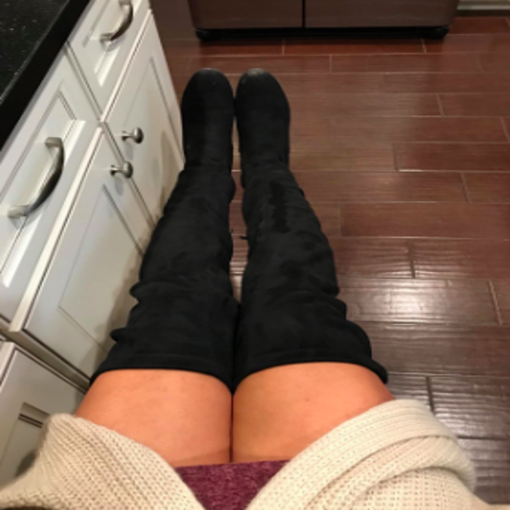 reviewer pic of person wearing a long sweater, short skirt with black ver the knee boots