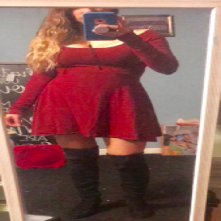 another reviewer pic of person wearing a red swing dress with a pair of black over the knee boots